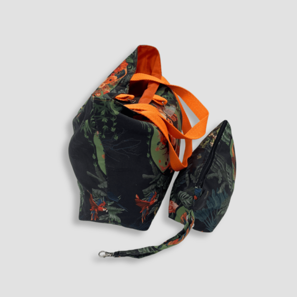 Cara lateral de bolso y neceser con estampado de Frida Kahlo y asas naranja