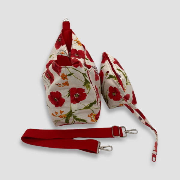 Cara lateral de bolso y neceser con estampado de amapolas rojas y fondo blanco