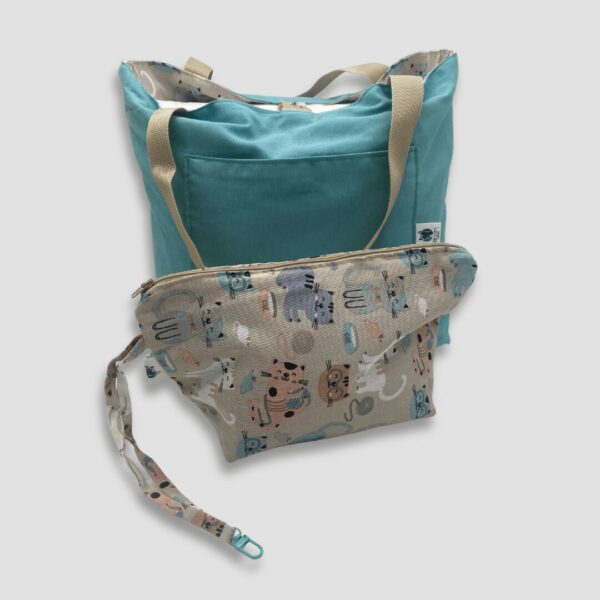 Bolso y neceser en loneta con estampado de gatos y fondo beige. Cara interna del bolso en azul aguamarina