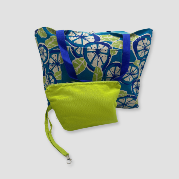 Cara frontal de bolso de loneta con estampado de limas en color azul y hojas verdes y neceser a juego en color verde oliva. Cara interna del bolso en color verde oliva.